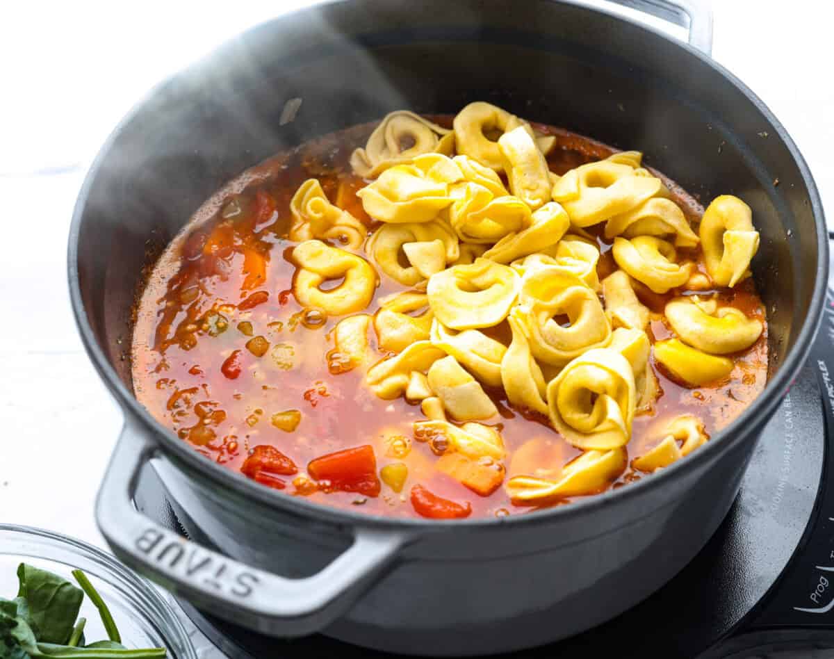 Tortellini added to the broth and veggie mixture.