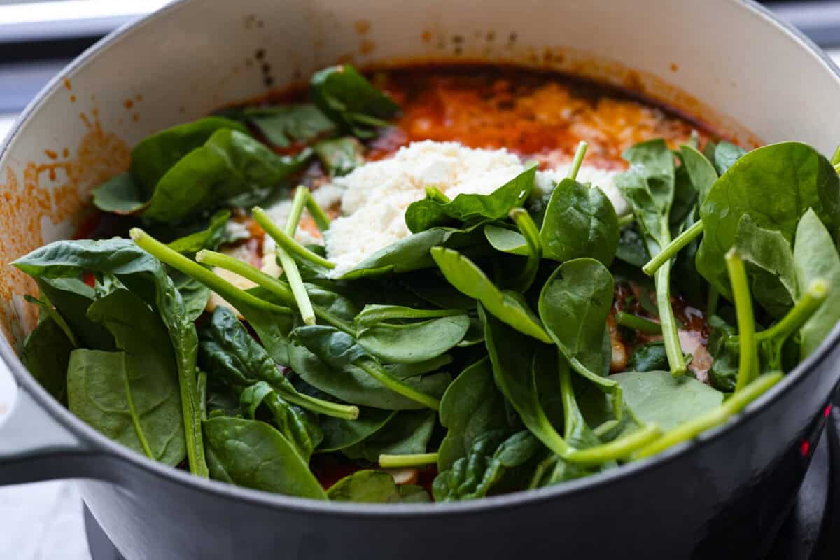 Spinach, ravioli, cream and parmesan added to the pot.